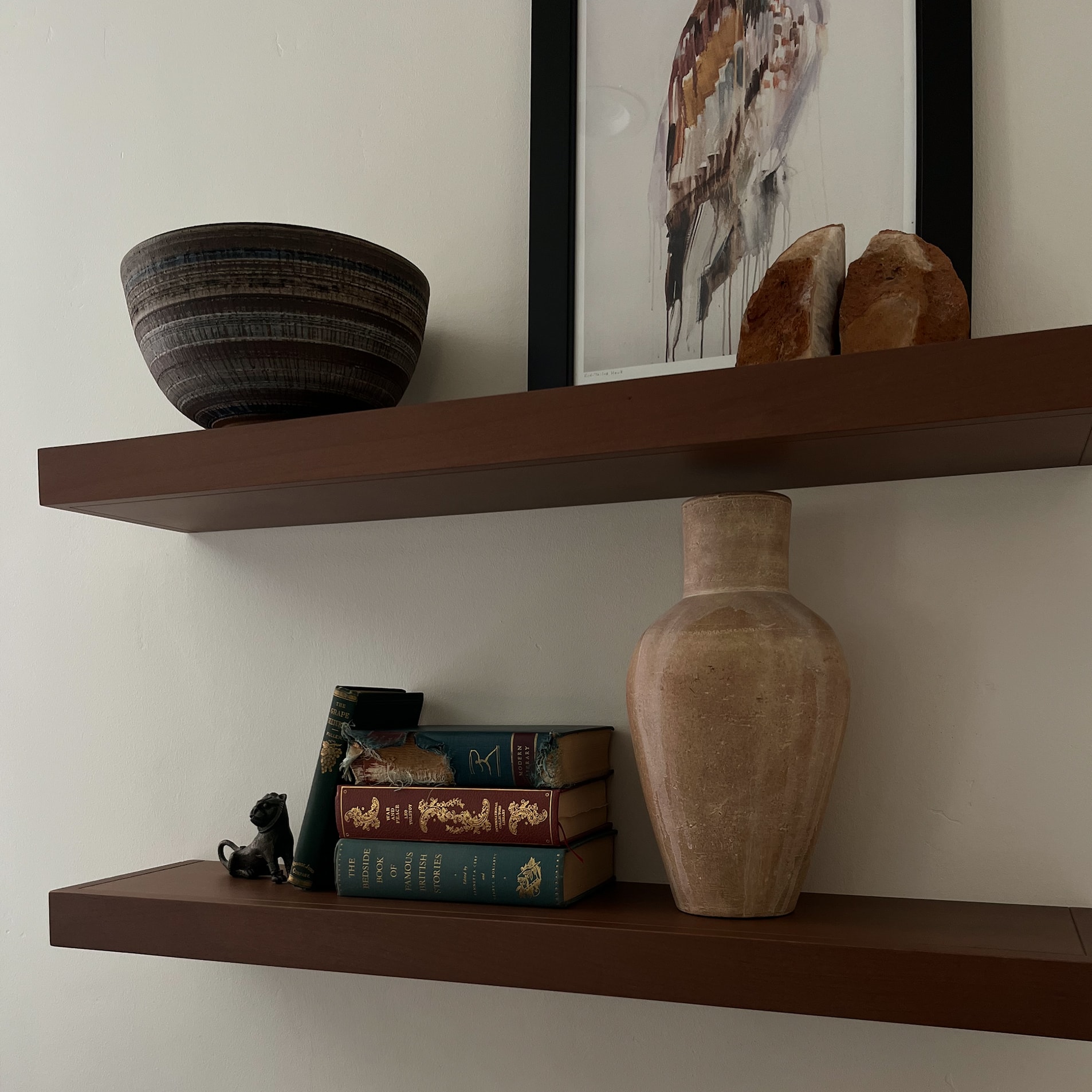 Collected ceramics, books and artwork on floating wooden shelves